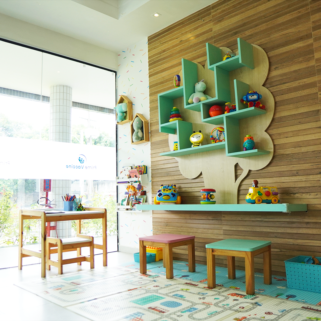 Espaço infantil da clínica com brinquedos e mesas